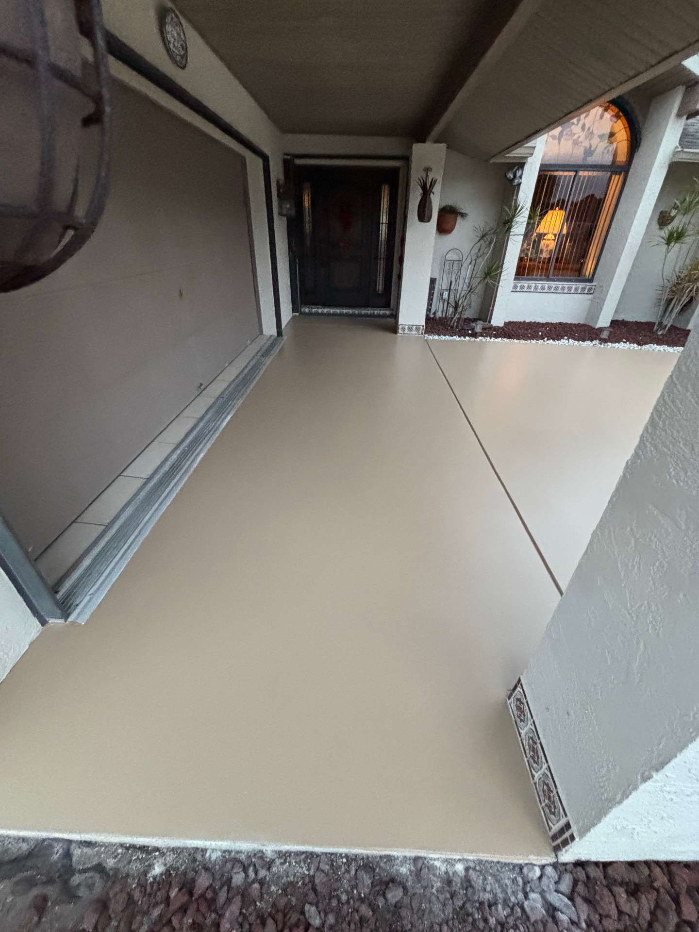 Freshly sealed tan concrete entryway and walkway at a Treasure Coast home by Millman Services.