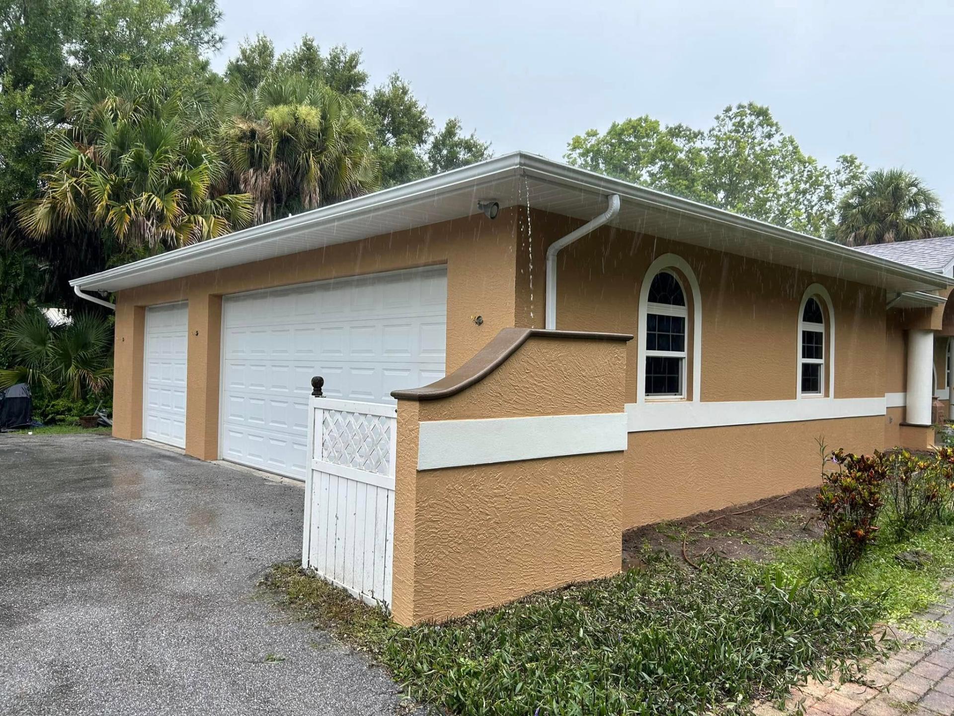 Exterior repaint of a Treasure Coast home with warm stucco and white trim by Millman Services.