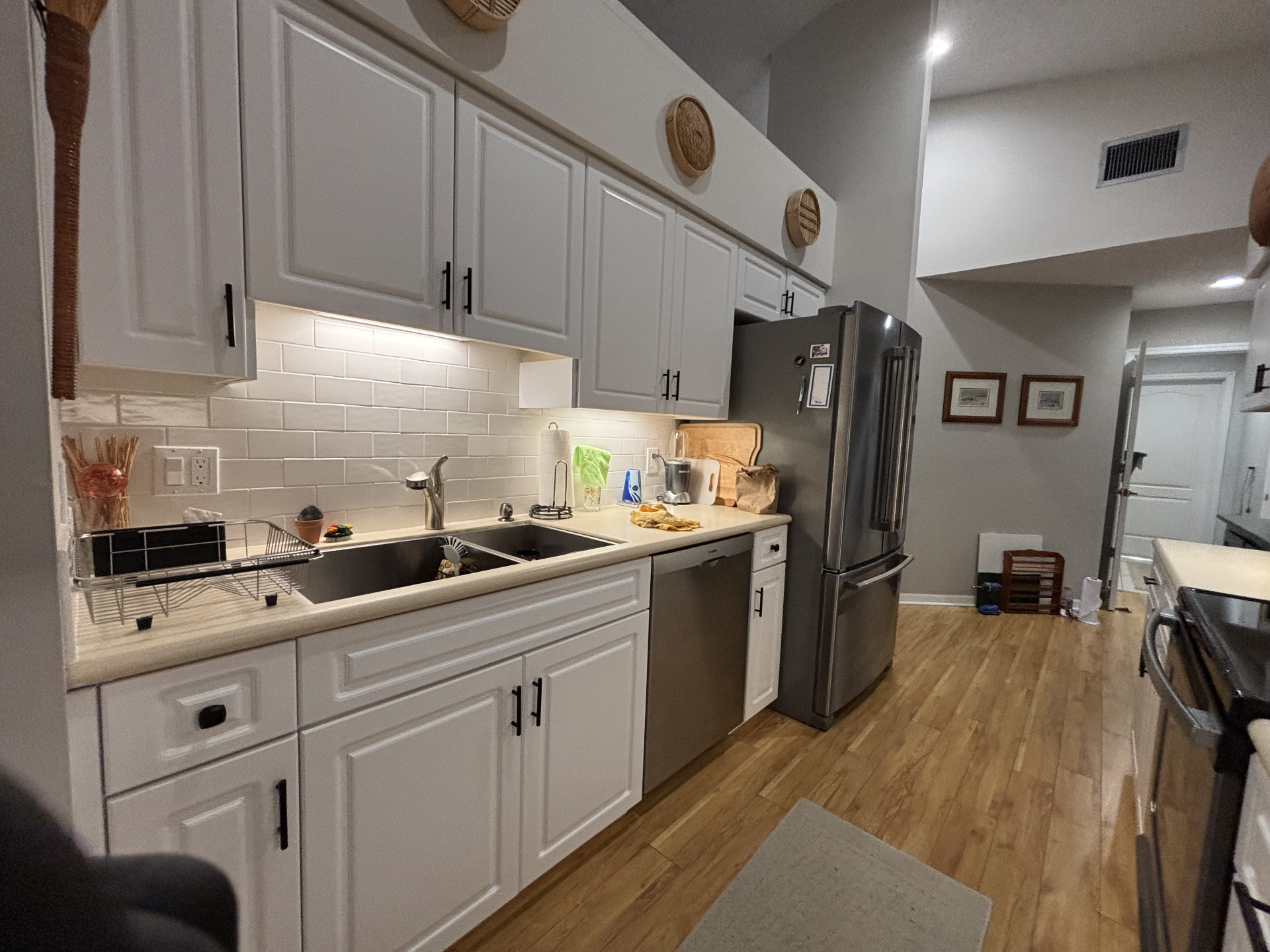 Freshly painted white kitchen cabinets with black hardware after a professional cabinet refinish