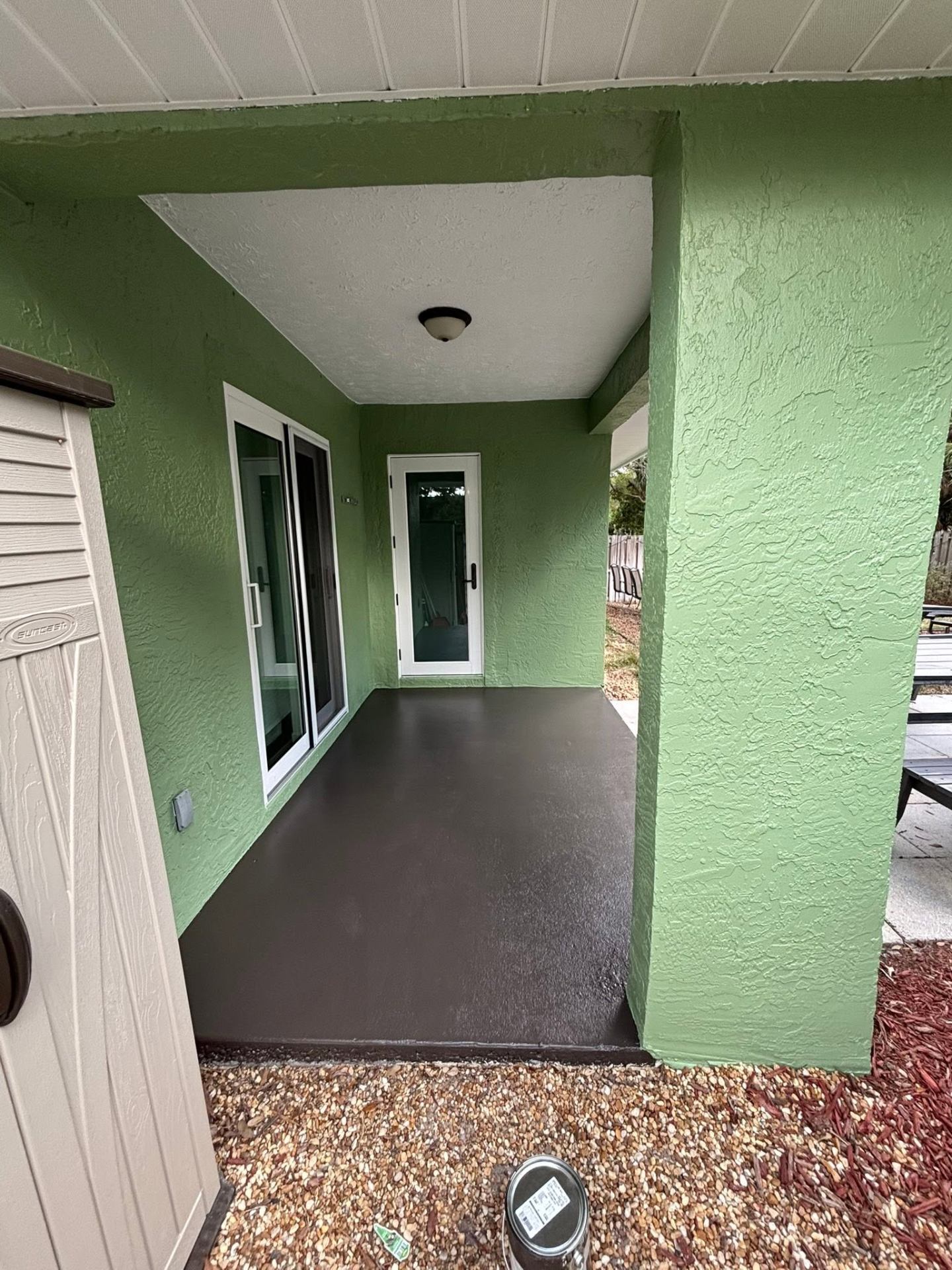 Freshly sealed dark brown covered patio floor at a Treasure Coast home by Millman Services.