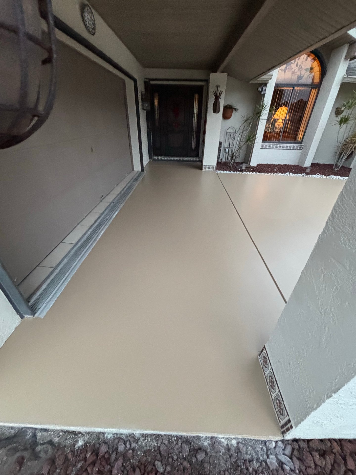 Freshly sealed tan concrete entryway and walkway at a Treasure Coast home by Millman Services.